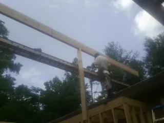 Carpenter setting a ridge beam over a new addition frame — Ice Dam Removal by Roofing Brothers in Berlin Center
