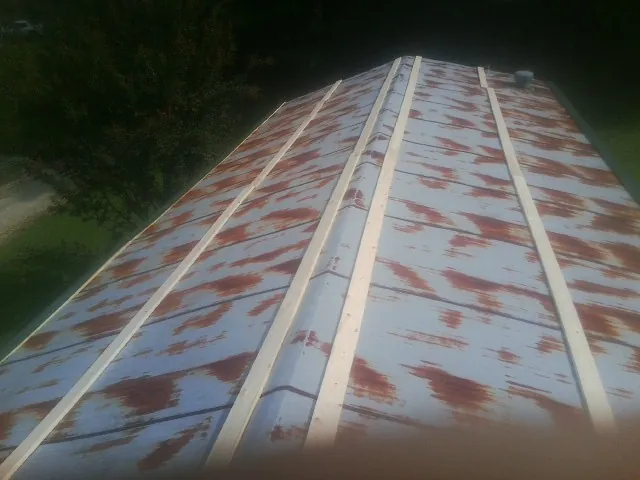 Rusted metal roof panels with new wood purlins before replacement — Storm Damage Roof Repair in Berlin Center by Roofing Brothers