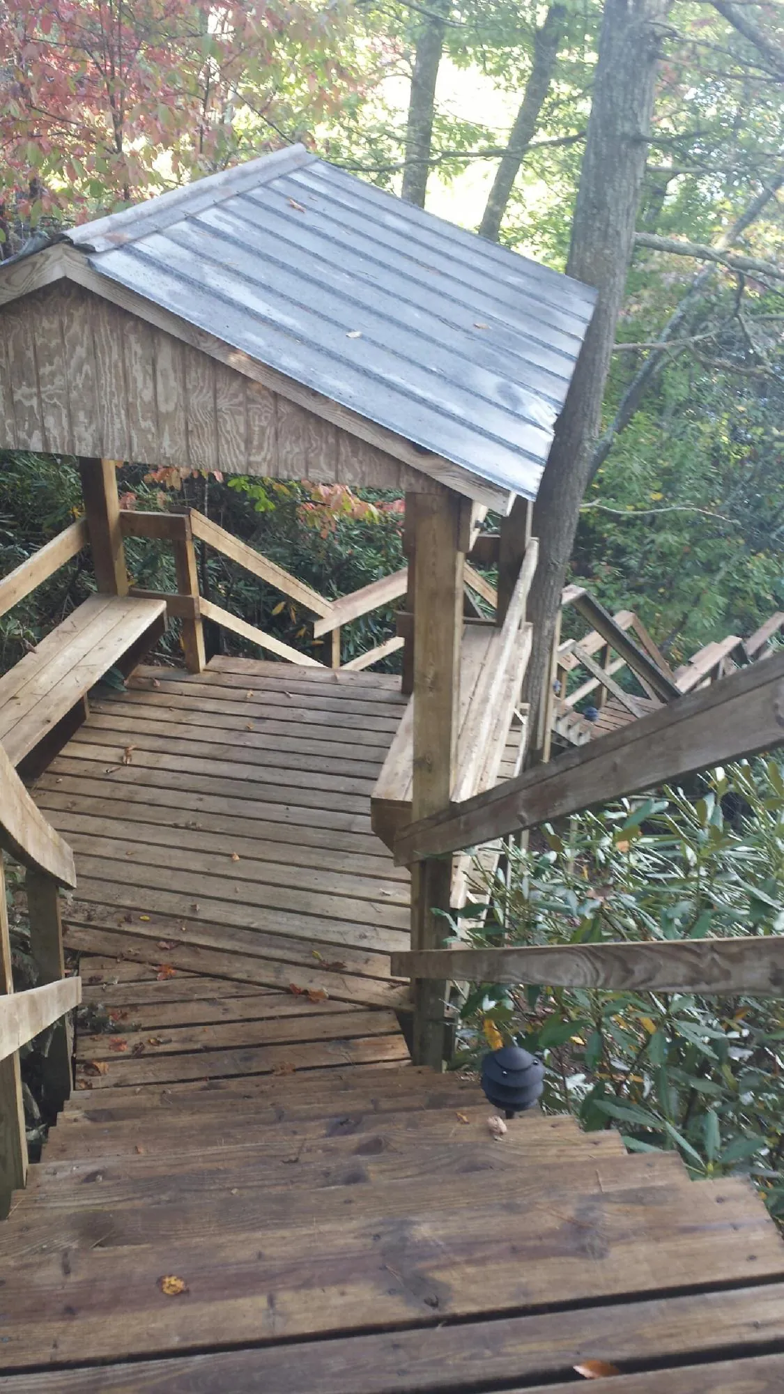 Metal roofed shelter over wooden steps on a wooded walkway — Skylight Repair & Installation work by our crew in Berlin Center