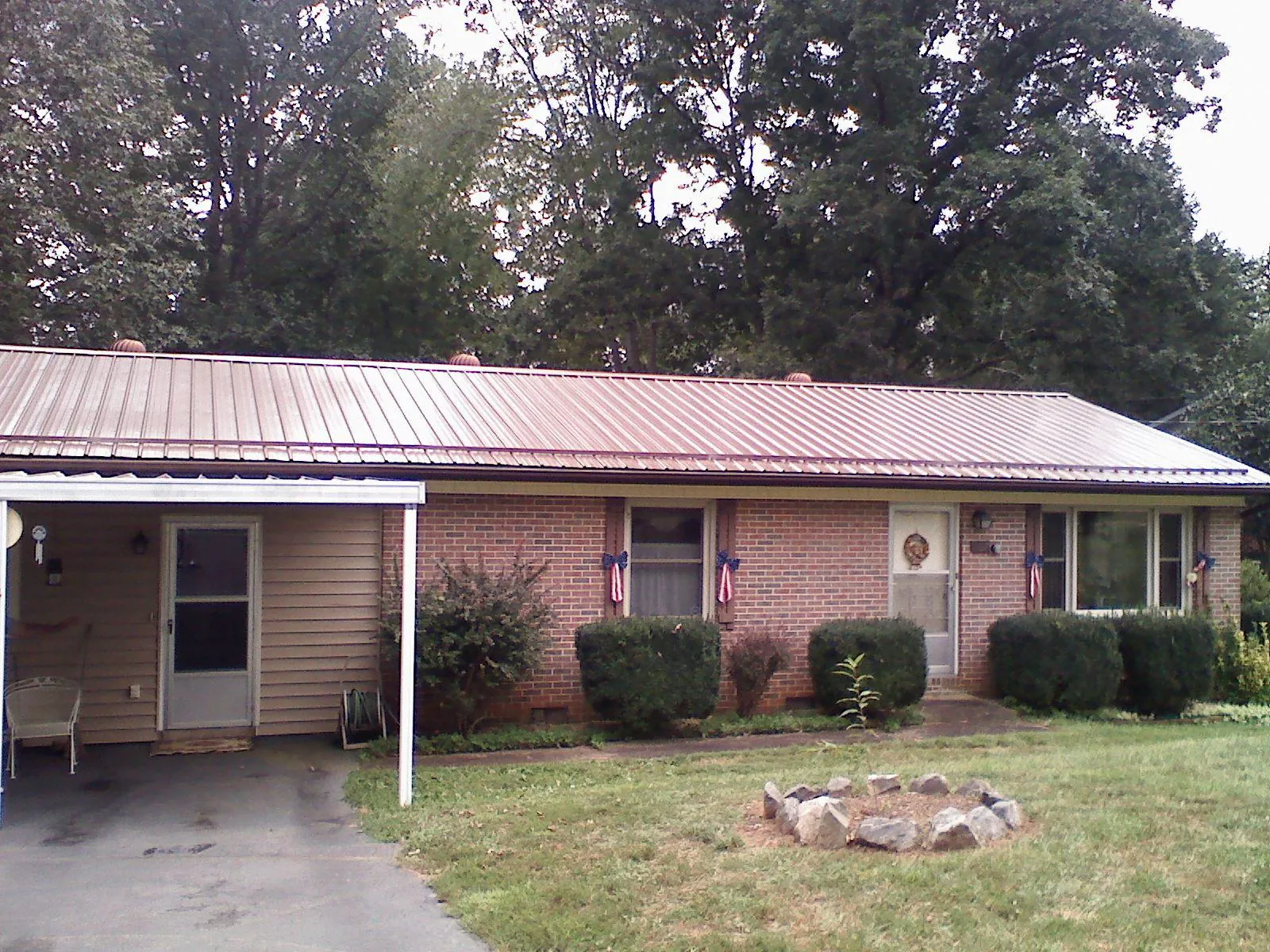 Bronze metal roof and carport on a brick ranch home — Roof Repair work by our crew in Berlin Center